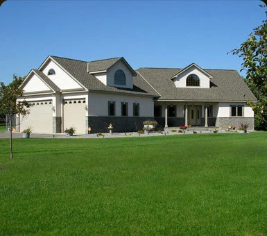 Finished custom home with a stone-and-siding exterior and attached garage, built by Powerbuilt Construction