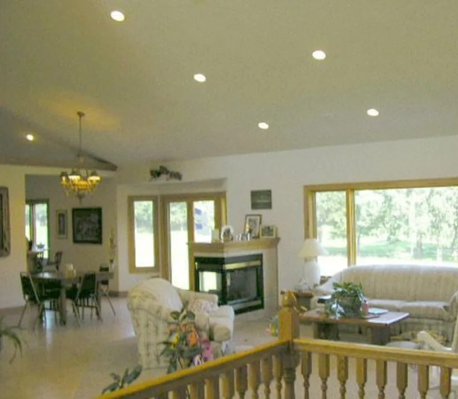 Vaulted great room with a see-through fireplace and a wall of windows, built by Powerbuilt Construction