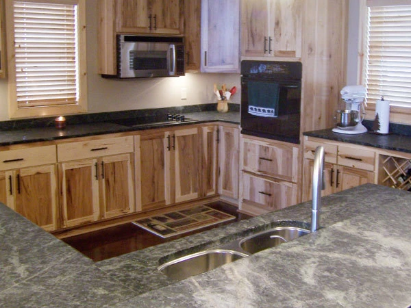 Finished hickory kitchen with granite countertops and a center island, built by Powerbuilt Construction in the North Metro