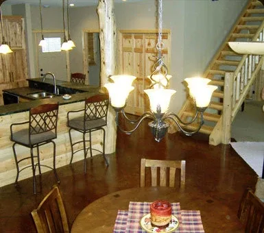 Log home kitchen and dining area with hickory cabinets and exposed log posts, built by Powerbuilt Construction